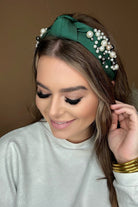 a twisted center knot headband with varying sizes of pearl detailing in green