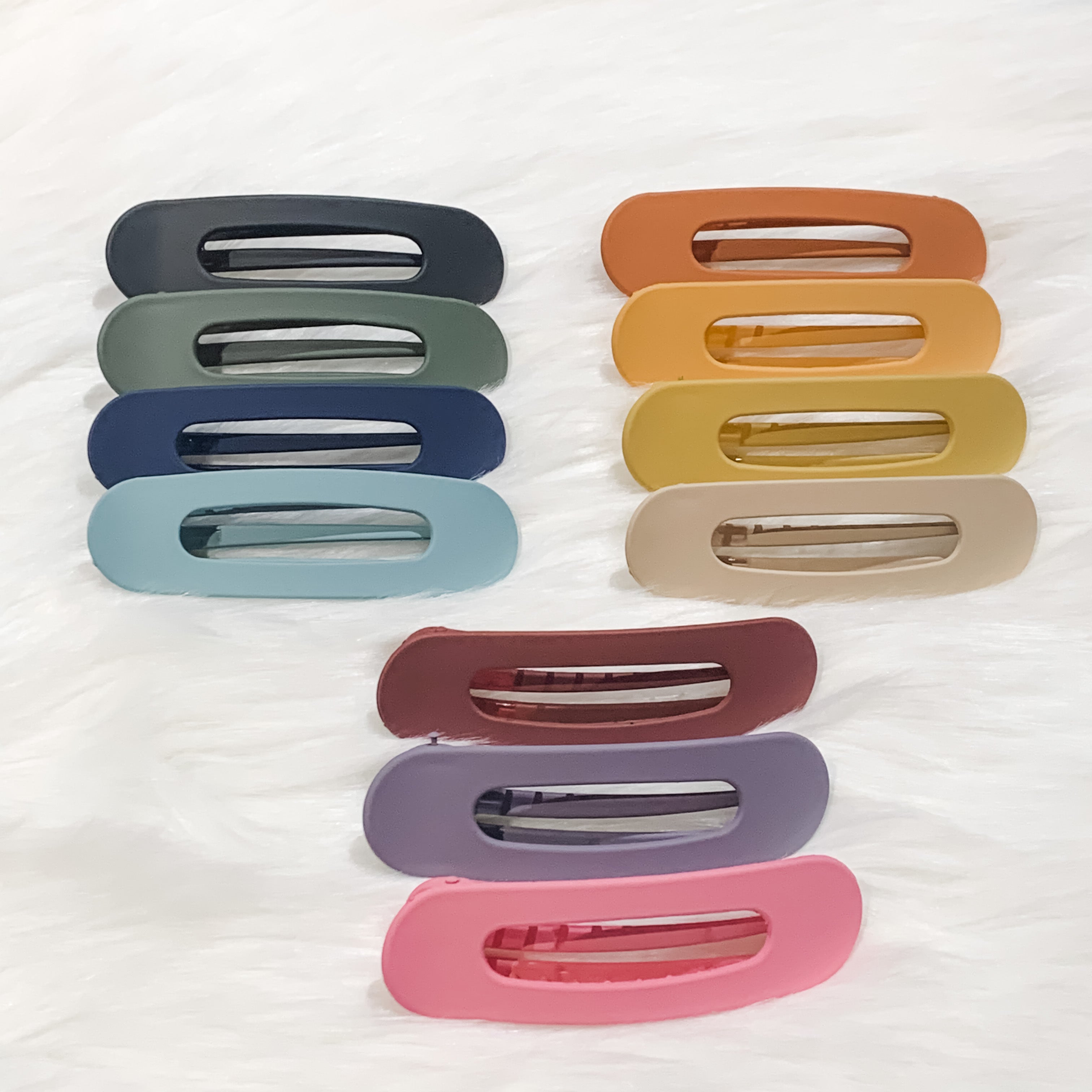 oversized spring back clip with curve design in black, blue, burgundy, hunter green, mustard, navy, neutral, peach, pink, purple, and terracotta