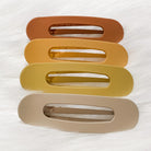 oversized spring back clip with curve design in terracotta, peach, mustard, and neutral