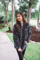 a long-sleeve fluffy pullover with a quarter zip, convenient pockets, and a foldable collar on a black leopard sherpa fabric