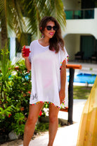 lightweight coverup made of breezy sheer material and multicolored pom pom trim detailing on white fabric