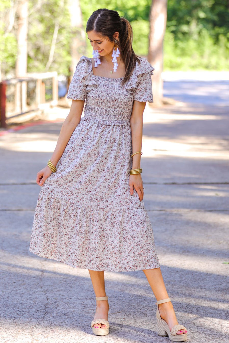 a lightweight ditsy floral midi dress with a smocked bodice, square neckline, ruffled trim and cap sleeves (wearable on or off the shoulder), and a relaxed silhouette that falls into a mid-calf hemline