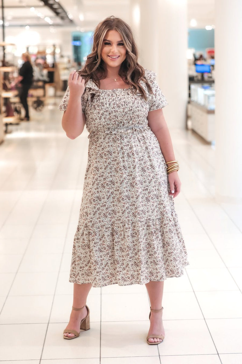 a lightweight ditsy floral midi dress with a smocked bodice, square neckline, ruffled trim and cap sleeves (wearable on or off the shoulder), and a relaxed silhouette that falls into a mid-calf hemline