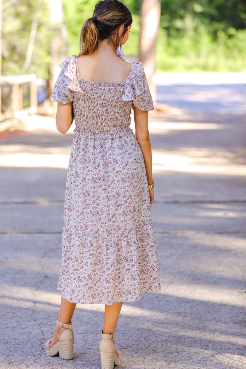 a lightweight ditsy floral midi dress with a smocked bodice, square neckline, ruffled trim and cap sleeves (wearable on or off the shoulder), and a relaxed silhouette that falls into a mid-calf hemline