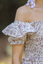 a lightweight ditsy floral midi dress with a smocked bodice, square neckline, ruffled trim and cap sleeves (wearable on or off the shoulder), and a relaxed silhouette that falls into a mid-calf hemline