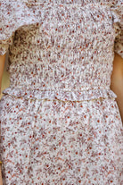 a lightweight ditsy floral midi dress with a smocked bodice, square neckline, ruffled trim and cap sleeves (wearable on or off the shoulder), and a relaxed silhouette that falls into a mid-calf hemline