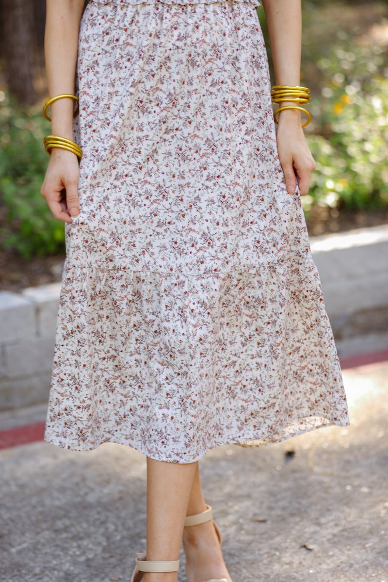 a lightweight ditsy floral midi dress with a smocked bodice, square neckline, ruffled trim and cap sleeves (wearable on or off the shoulder), and a relaxed silhouette that falls into a mid-calf hemline