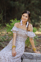 a lightweight ditsy floral midi dress with a smocked bodice, square neckline, ruffled trim and cap sleeves (wearable on or off the shoulder), and a relaxed silhouette that falls into a mid-calf hemline