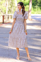 a lightweight ditsy floral midi dress with a smocked bodice, square neckline, ruffled trim and cap sleeves (wearable on or off the shoulder), and a relaxed silhouette that falls into a mid-calf hemline
