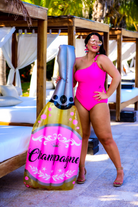 solid pink one-piece swimsuit with a one-shoulder neckline, gold ring detailing on chest, and removable padding