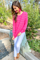 lightweight horizontal striped top with long sleeves, a crew neckline, and a slouched silhouette that ends in a rounded hemline on a solid pink base