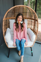 lightweight horizontal striped top with long sleeves, a crew neckline, and a slouched silhouette that ends in a rounded hemline on a solid mauve base