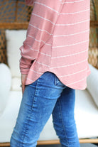 lightweight horizontal striped top with long sleeves, a crew neckline, and a slouched silhouette that ends in a rounded hemline on a solid mauve base