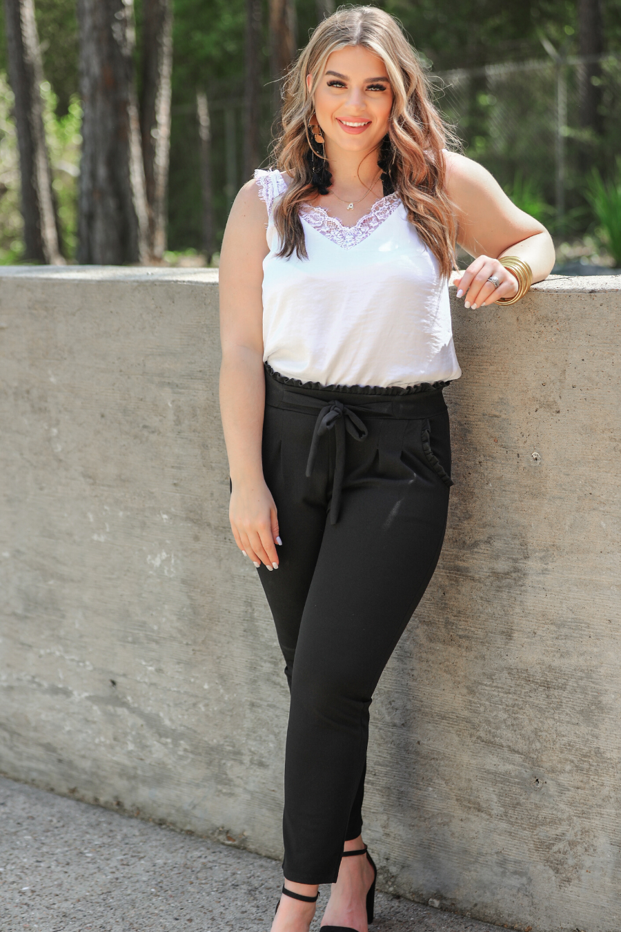 high-waisted paper-bag silhouette pants with a ruffle trim and sash tie, lightweight drapey fabric, straight legs, side pockets polished with a flirty ruffle, and unlined for breezy comfort in black