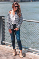 long sleeve drop shoulder shacket with button closures, a button-down front, a collared neckline, chest pockets, and back detailing on a black and white houndstooth print