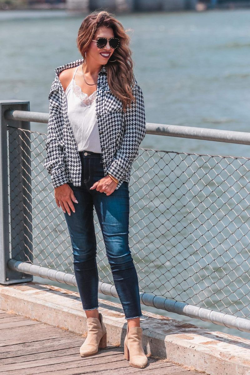 long sleeve drop shoulder shacket with button closures, a button-down front, a collared neckline, chest pockets, and back detailing on a black and white houndstooth print