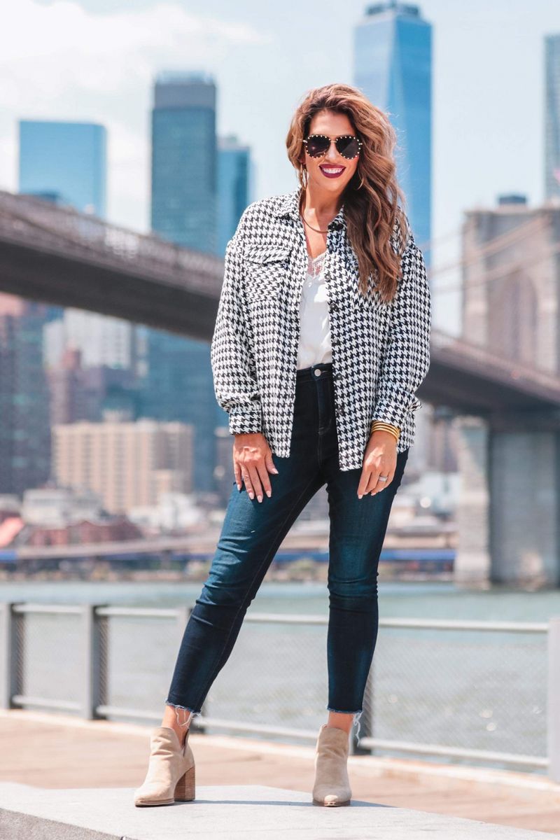 long sleeve drop shoulder shacket with button closures, a button-down front, a collared neckline, chest pockets, and back detailing on a black and white houndstooth print