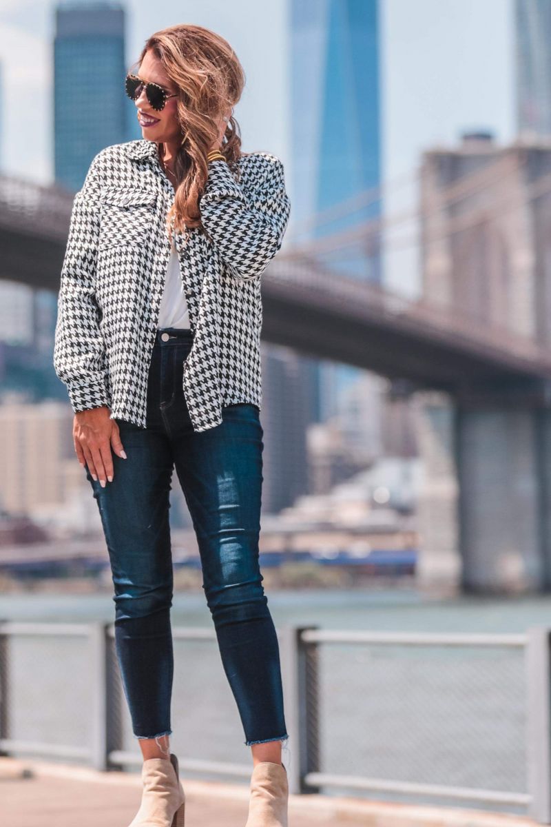 long sleeve drop shoulder shacket with button closures, a button-down front, a collared neckline, chest pockets, and back detailing on a black and white houndstooth print