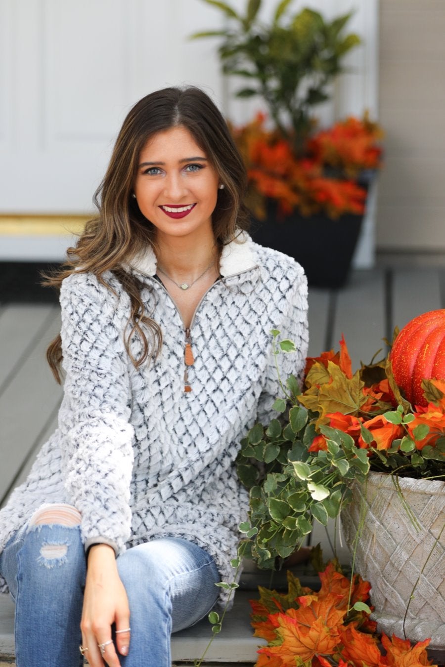 a long-sleeve fluffy pullover with a quarter zip, convenient front pockets, a foldable collar, and lining on ivory with a navy background and diamond snake pattern print shearling material that runs oversized