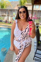 a one-piece swimsuit made of stretchy material with a scoop back, chunky straps, a versatile accent tie, and removable padding on a neutral color block animal print pattern fabric