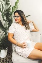 a neutral taupe animal print lounge set crafted from soft stretch fabric with a short-sleeve V-neck top, matching pull-on shorts, elastic waistband, side pockets, and relaxed fit