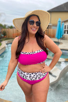 two-piece swimsuit made of stretchy material with a square neckline, adjustable spaghetti straps, and removable padding paired with high-waisted bottoms on a hot pink fabric and a leopard print trim&nbsp;