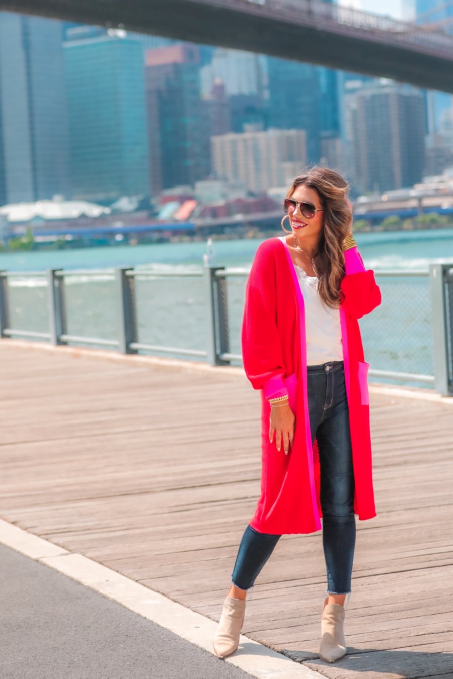 a long-sleeve cardigan with an open-front silhouette, bold pink and red color blocking, contrast cuffs, chic trim detailing, functional side pockets, and a relaxed straight fit