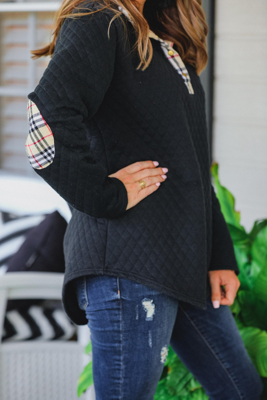 a long-sleeve pullover with a quilted pattern, gold button details, a foldable collar, a round hem, and matching plaid elbow patch and quarter button-up neckline