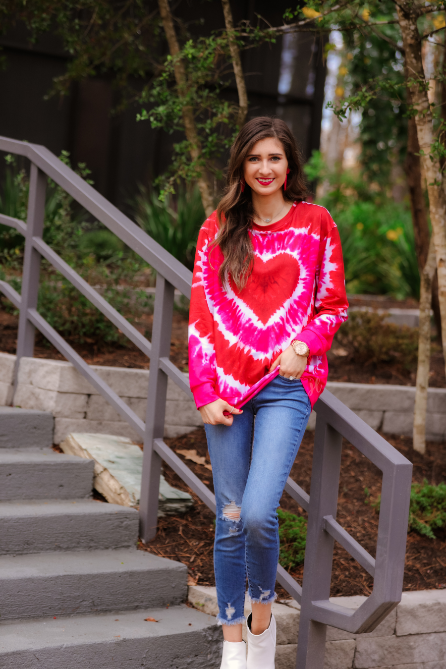 a red lightweight long-sleeve knit top with a bold heart motif layered over a vibrant tie-dye pattern, a flattering scoop neckline, and a streamlined silhouette that finished with a straight hem