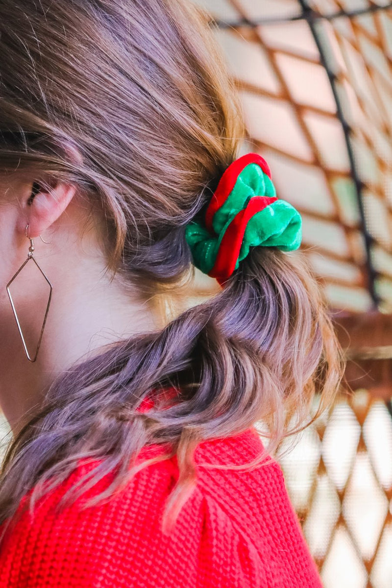 a plush velvet scrunchie in a rich nostalgic colorway (classic green with red trim) with contrasting trim and comfortable elastic