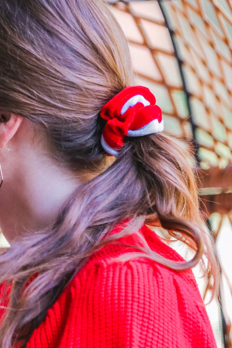 a plush velvet scrunchie in a rich nostalgic colorway (bold red with white trim) with contrasting trim and comfortable elastic