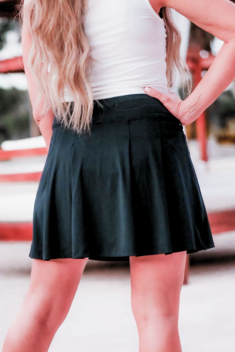 a slimming true to size solid black skort with built-in shorts, interior side pockets, and a pleated back