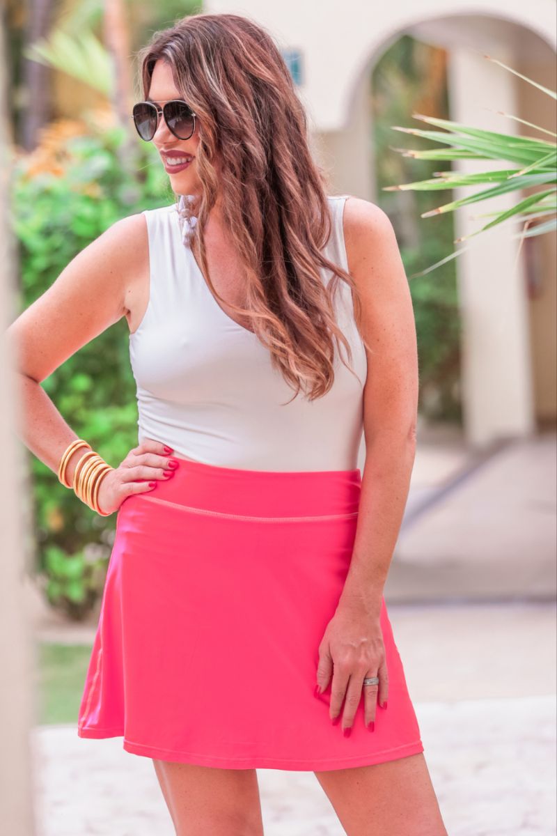 a slimming true to size solid pink skort with built-in shorts, interior side pockets, and a pleated back