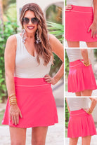 a slimming true to size solid pink skort with built-in shorts, interior side pockets, and a pleated back