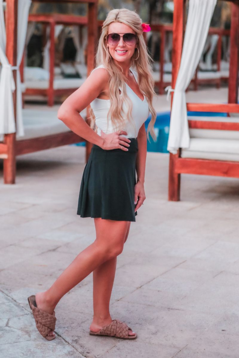 a slimming true to size solid black skort with built-in shorts, interior side pockets, and a pleated back