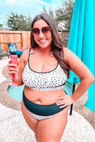 two-piece swimsuit made of lightweight four-way stretchy material and subtle ribbed texturing on a neutral leopard print with a bralette-style top, adjustable spaghetti straps, removable padding, a black band, and flattering form-fitting silhouette paired with high waistline bottoms with a black solid band for added tummy control